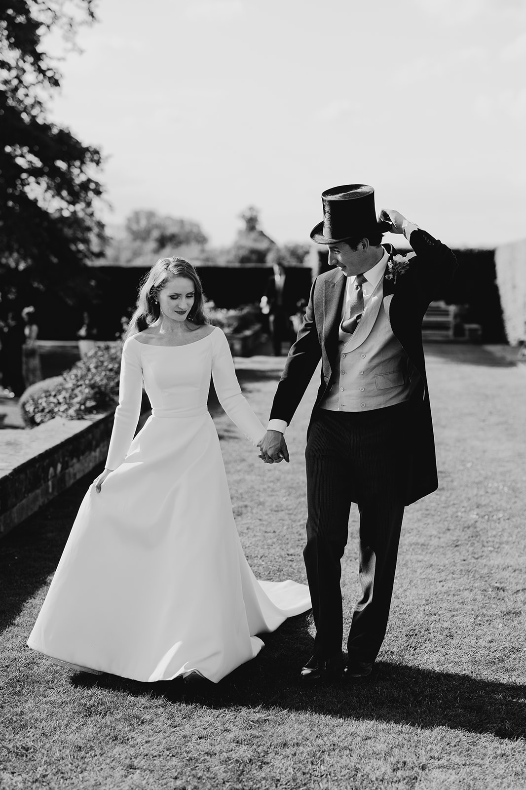 Wedding photography at Buckhurst park wedding as bride and groom walk though grounds