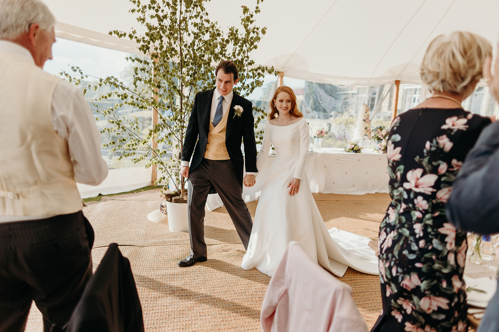 The couple's entrance heralded by cheers at their Buckhurst Park wedding reception.