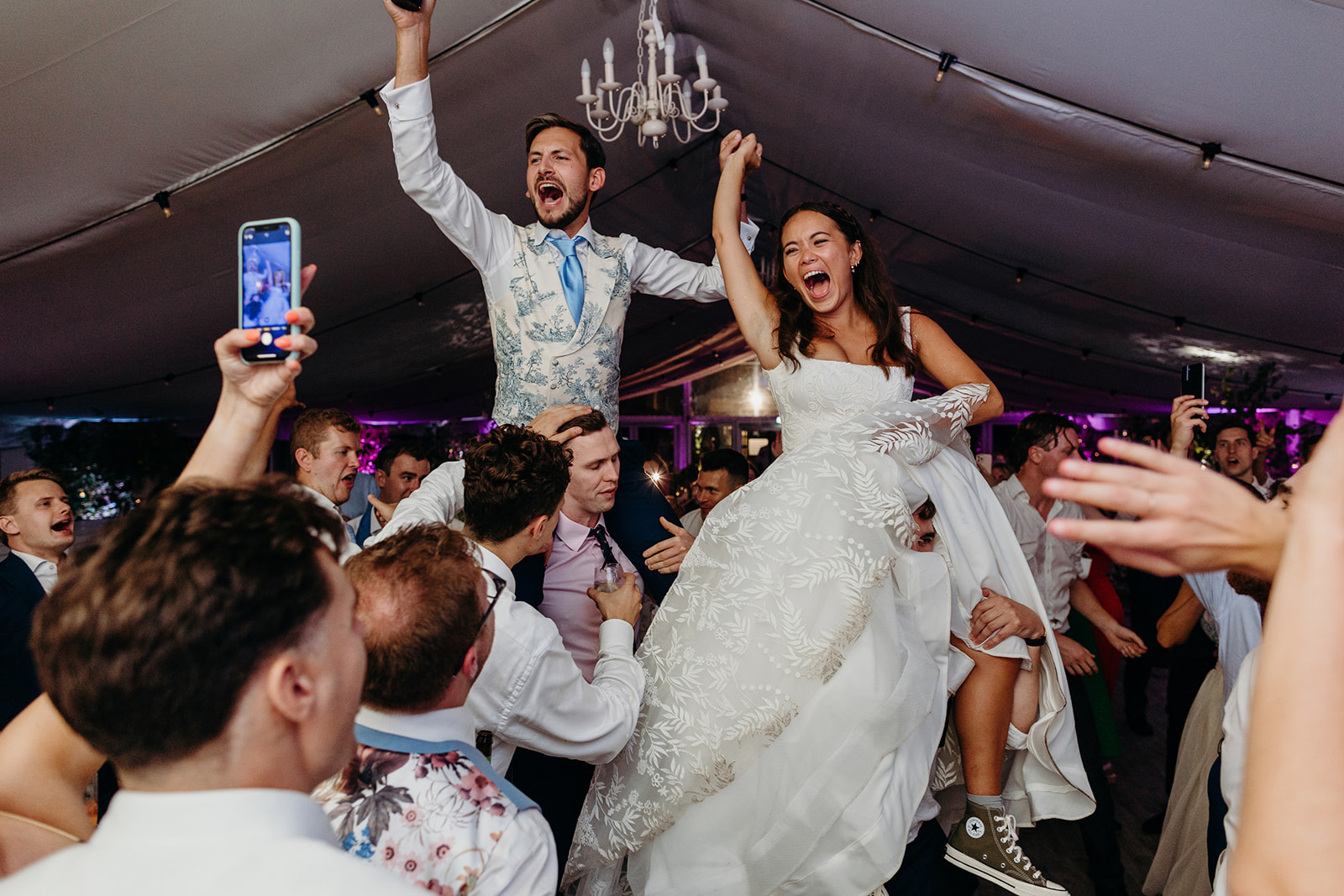 bride and groom on guests shoulders during their wedding party at Chiswick house 