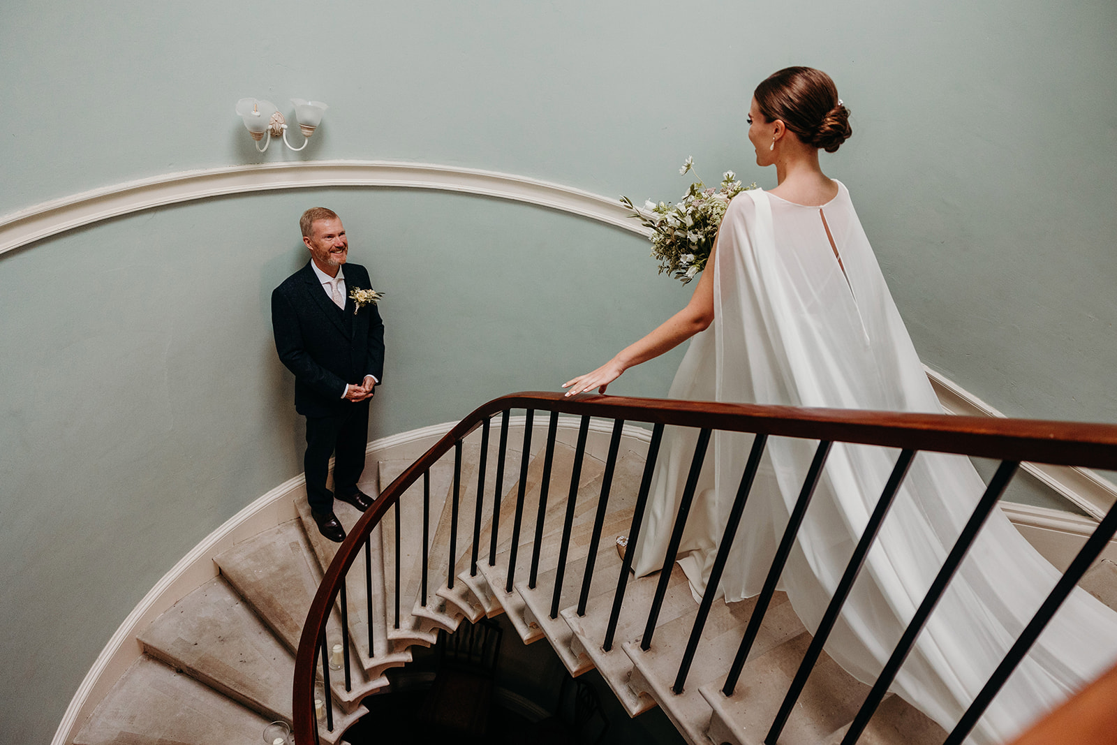 father of bride waiting for daughter on steps at wedding