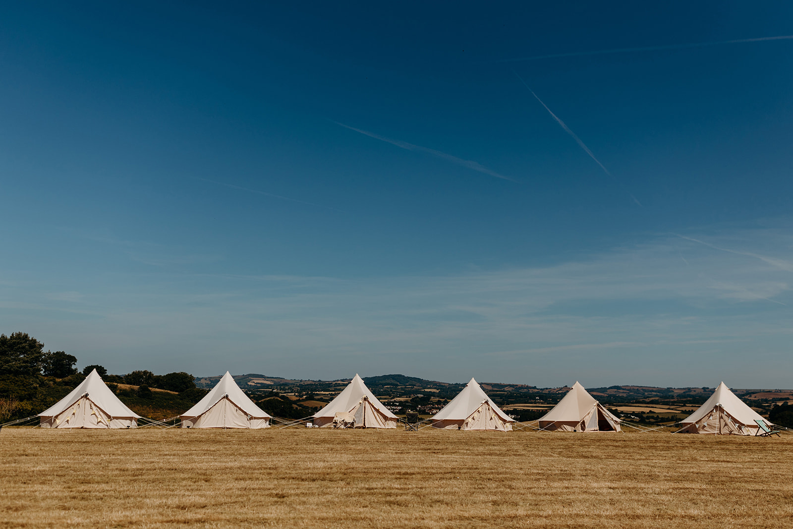 Bell tents for Dorset wedding with deep blue sky in background