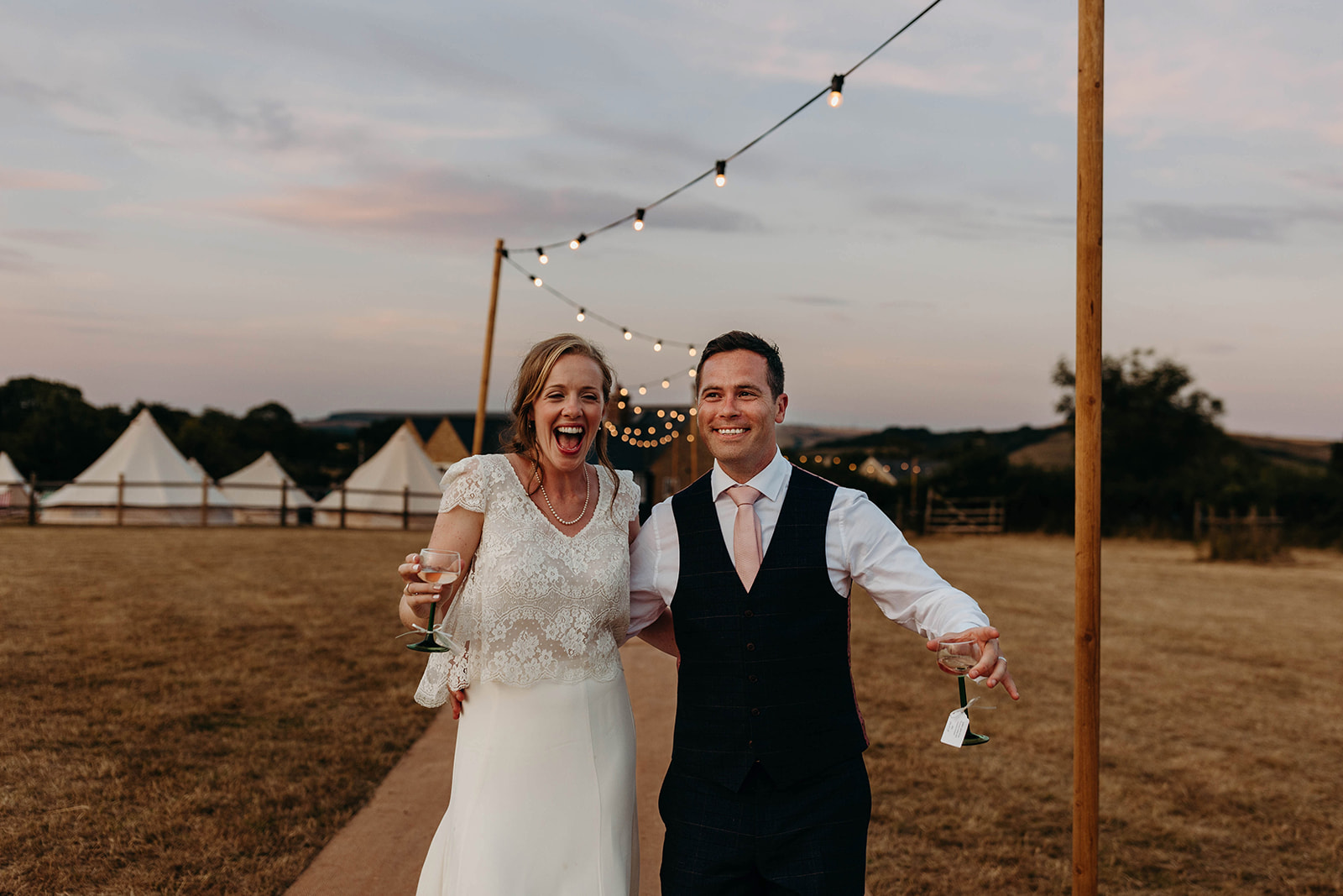 Bride and groom smiling as they return to Dorset Marquee wedding