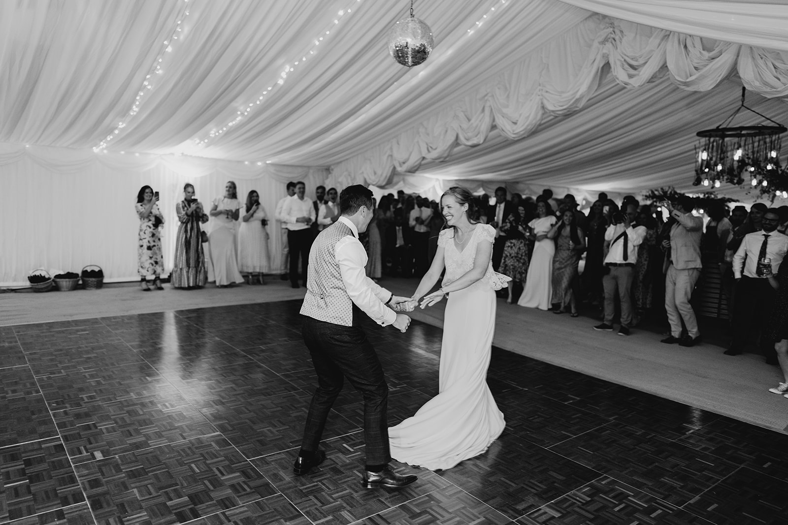 first dance at marquee wedding with guests in background