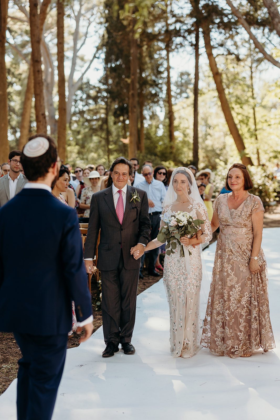 Bride being walked down aisle to outdoor ceremony in France