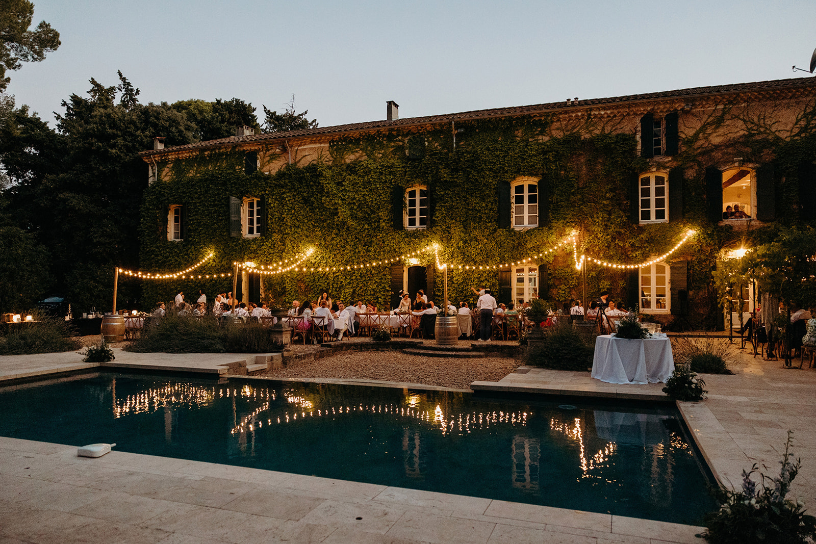 Festoon lights adding drama to an outdoor wedding dinner at Domaine Saint Hilaire wedding