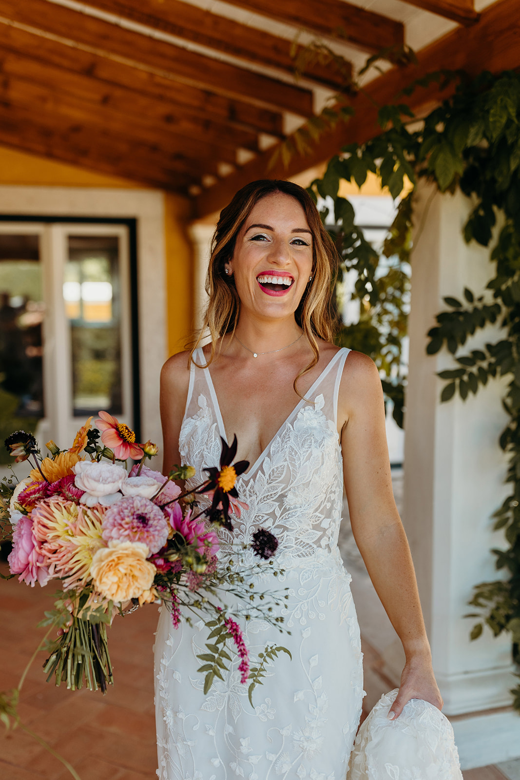 bride smiling with a bright colourful bouquet in hand
