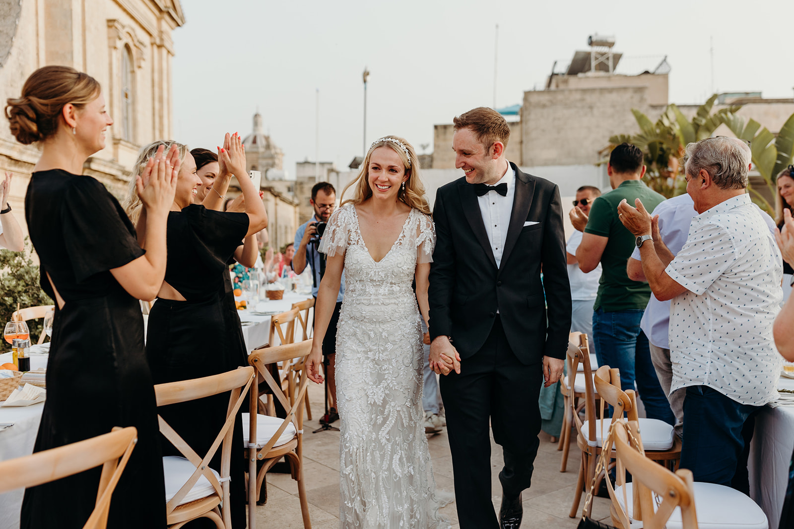 Bride and groom making an entrance to their rooftop wedding dinner in Malta