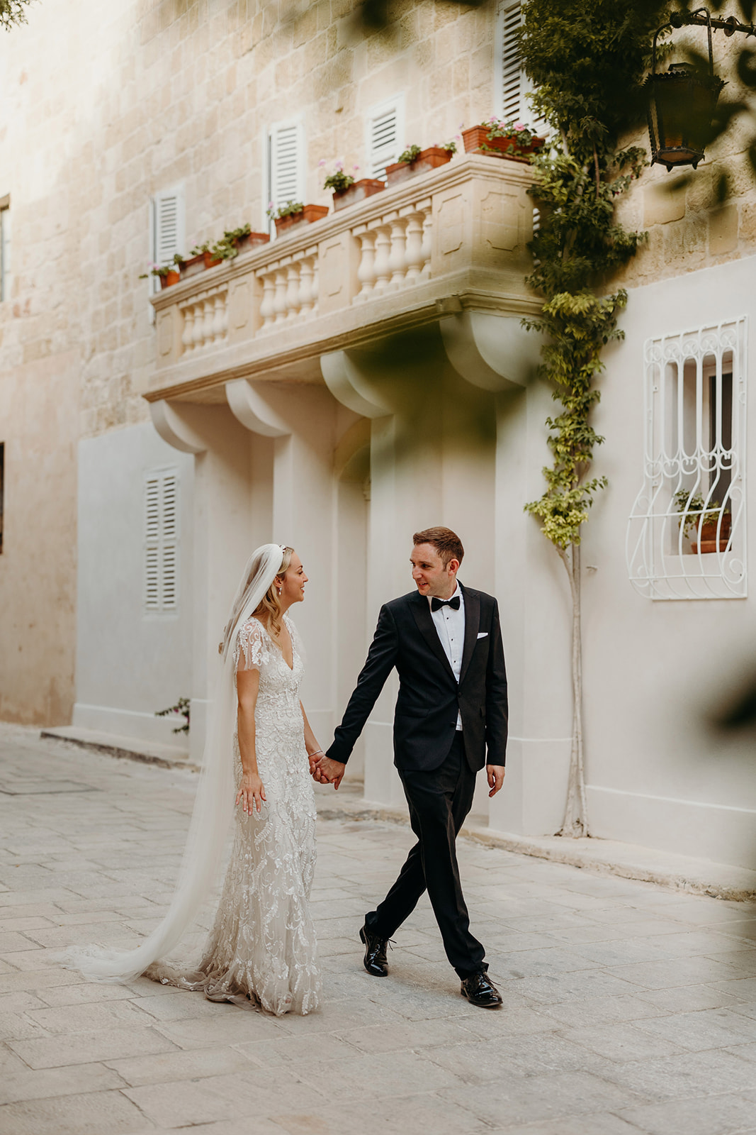 Bride and groom walking along rustic streets in Rabat in Malta