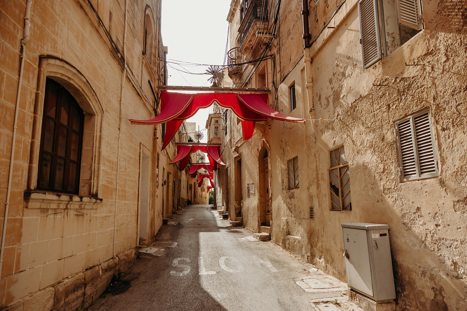 Flags adorned to sun-kissed buildings in Rabat, Malta for festival celebrations