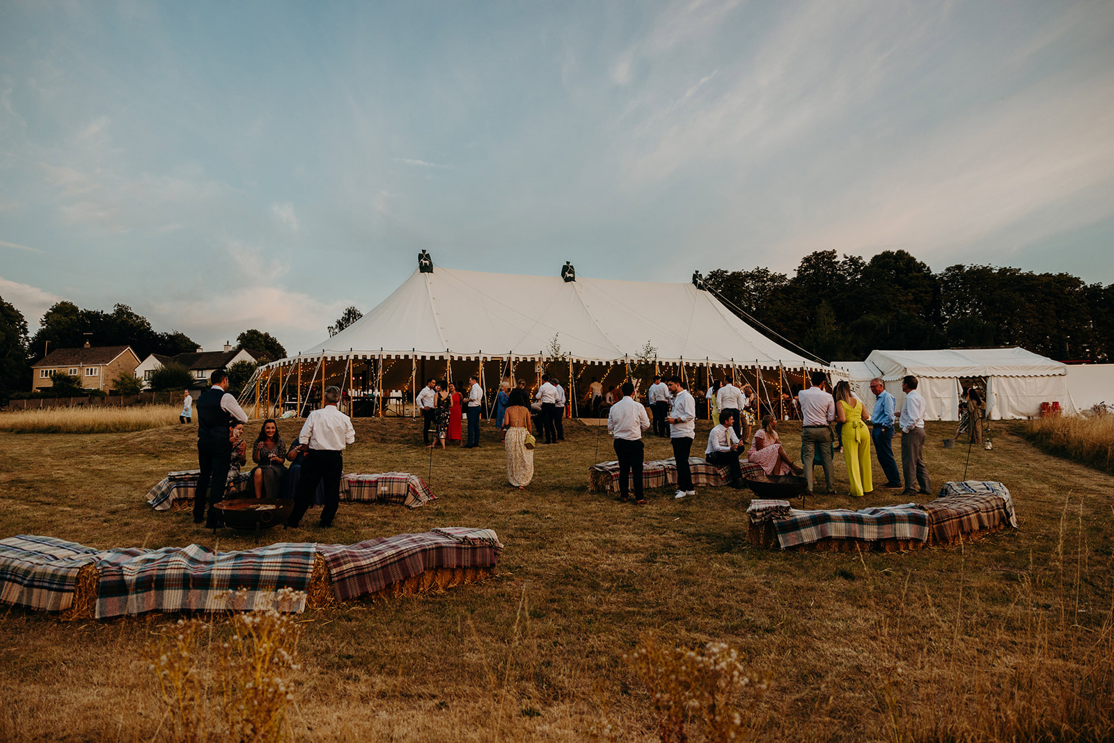 Evening light as guests enjoy home marquee wedding in Wiltshire