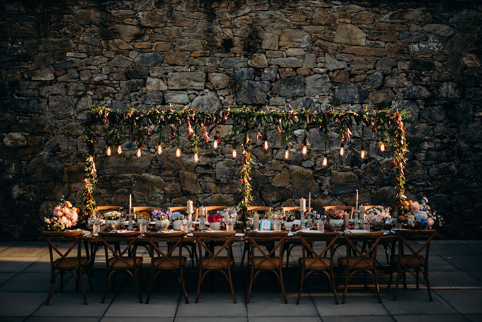 Beautiful outdoor reception table lit up by festoon lighting