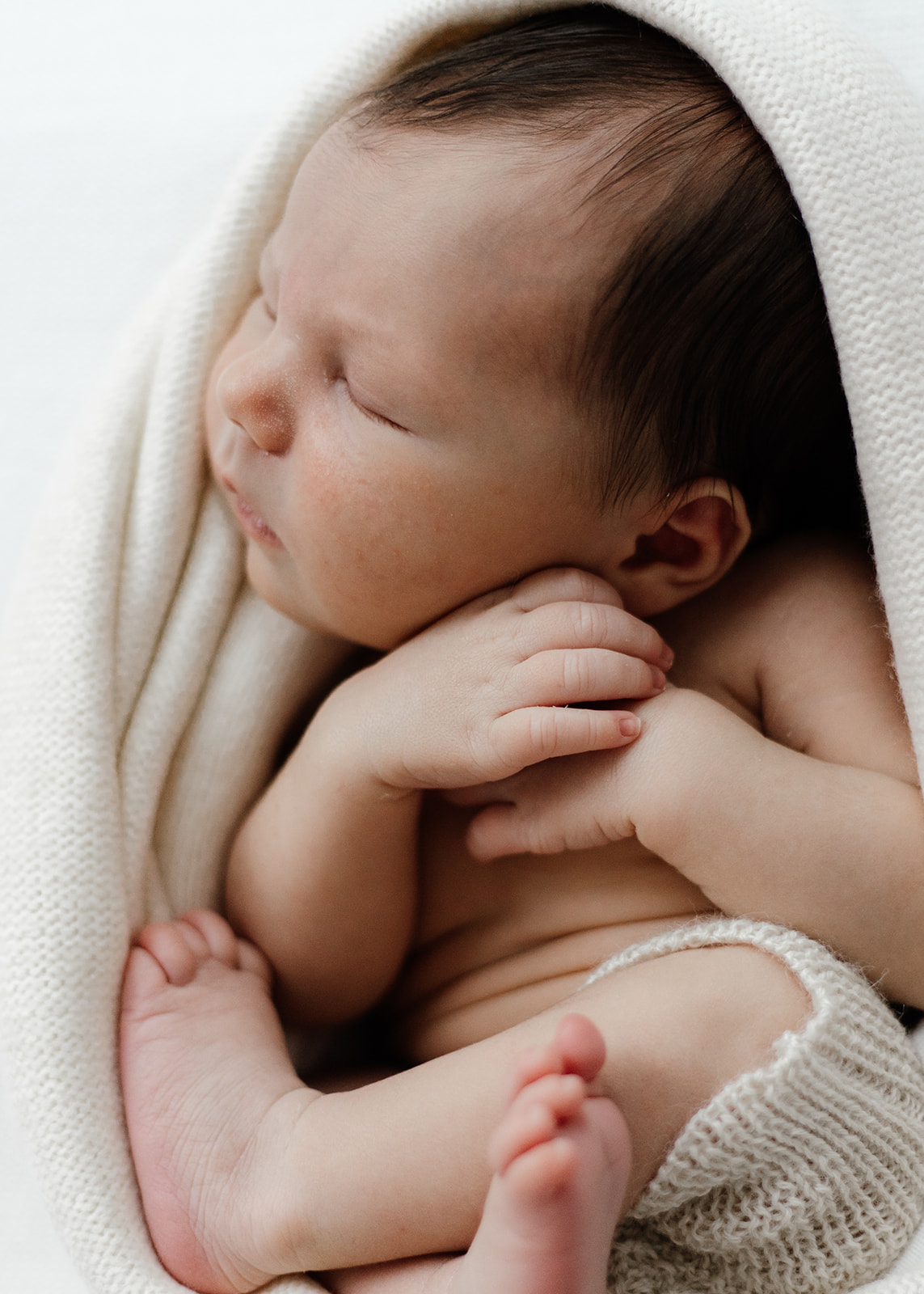 baby boy curled up at newborn photography session