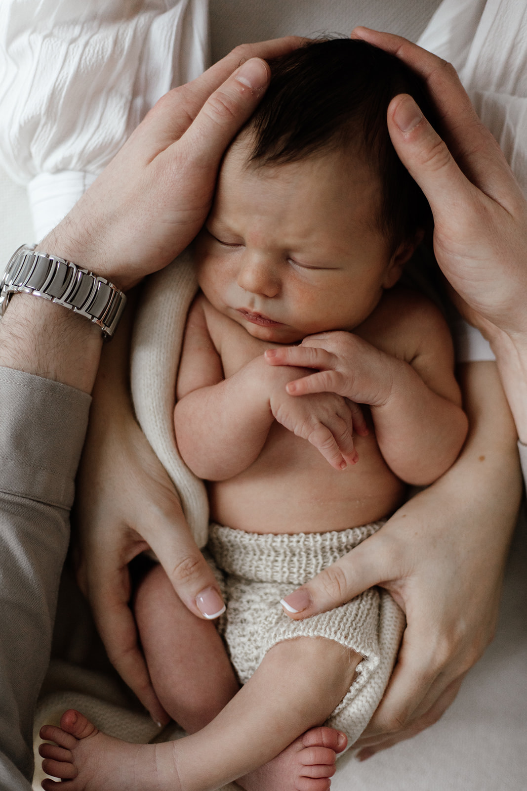 Newborn Photography with baby boy wrapped in parents hands