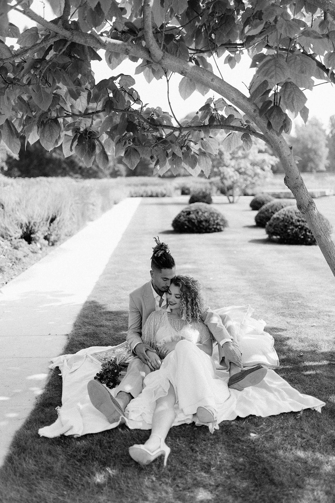 bride and groom sitting on blanket in walled gardens at Middleton lodge