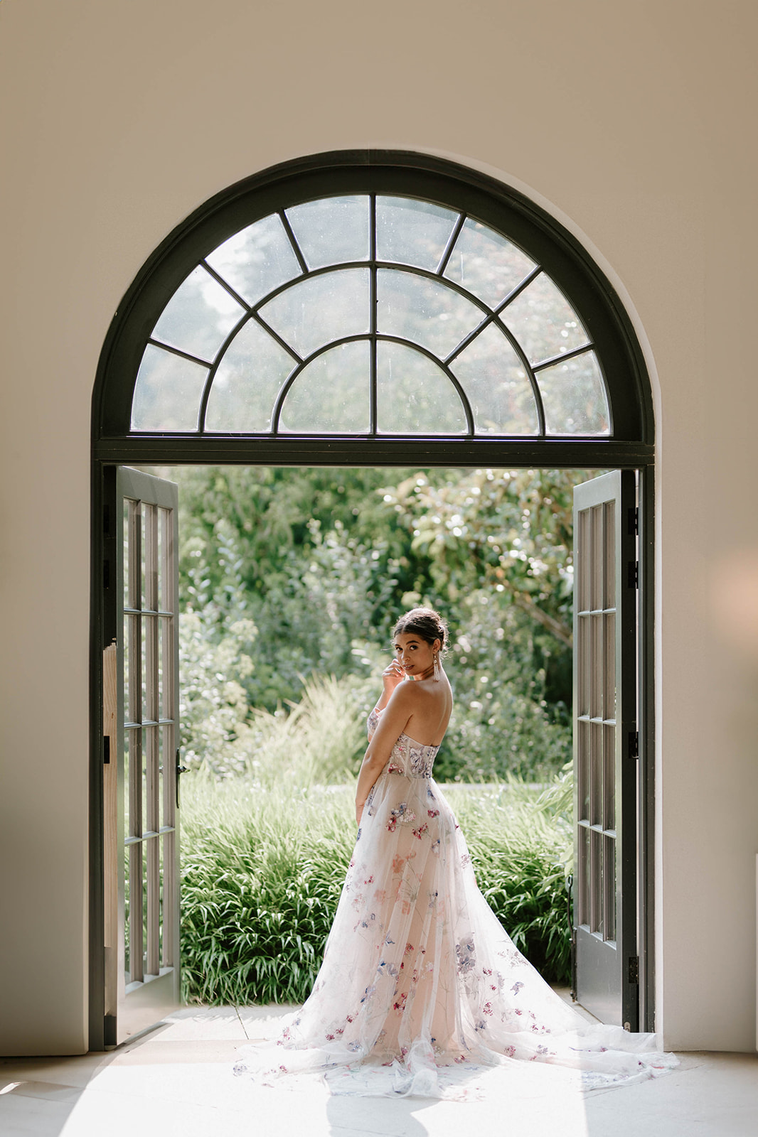 bride standing in arched window of fig house at Middleton lodge