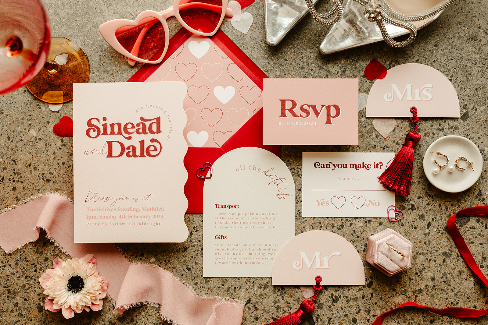 flat lay of wedding stationery red and pink details