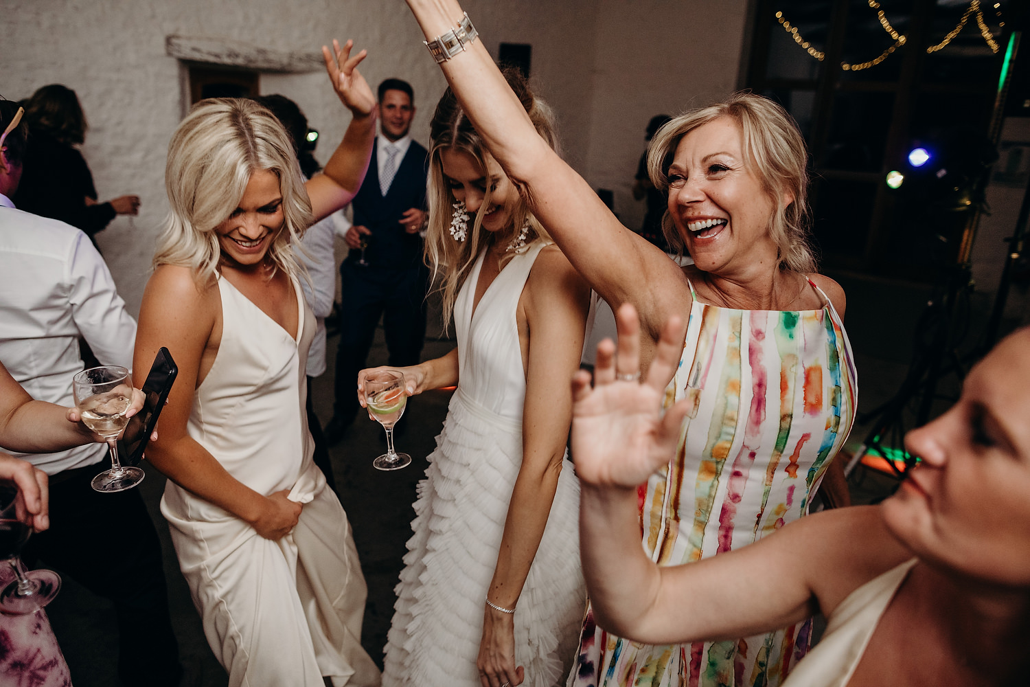 bride dances with mother and bridesmaids at wedding