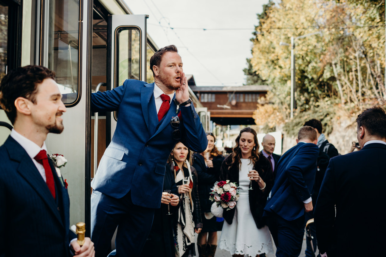 best man announcing guests to board train to travel up alps