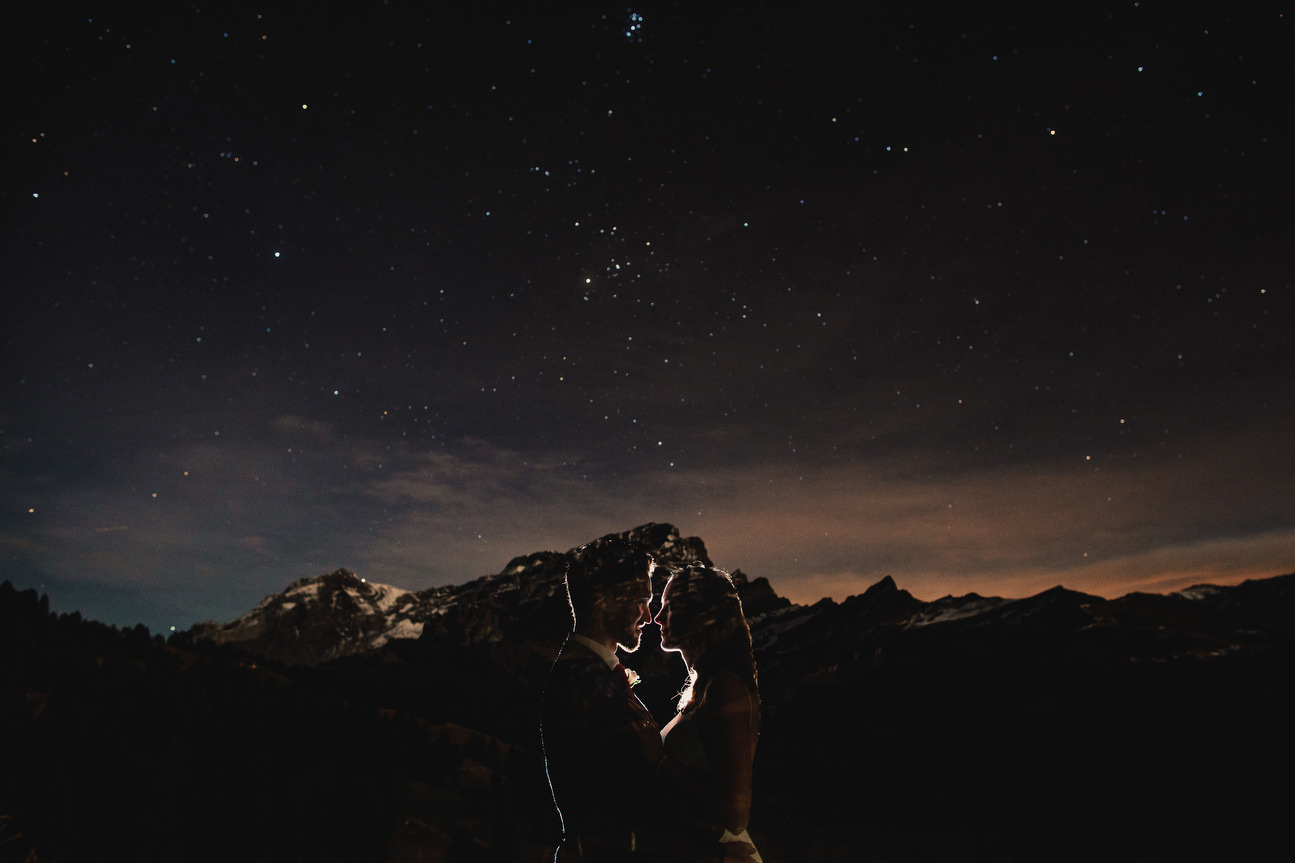 bride and groom portrait at night with mountains and stars in background