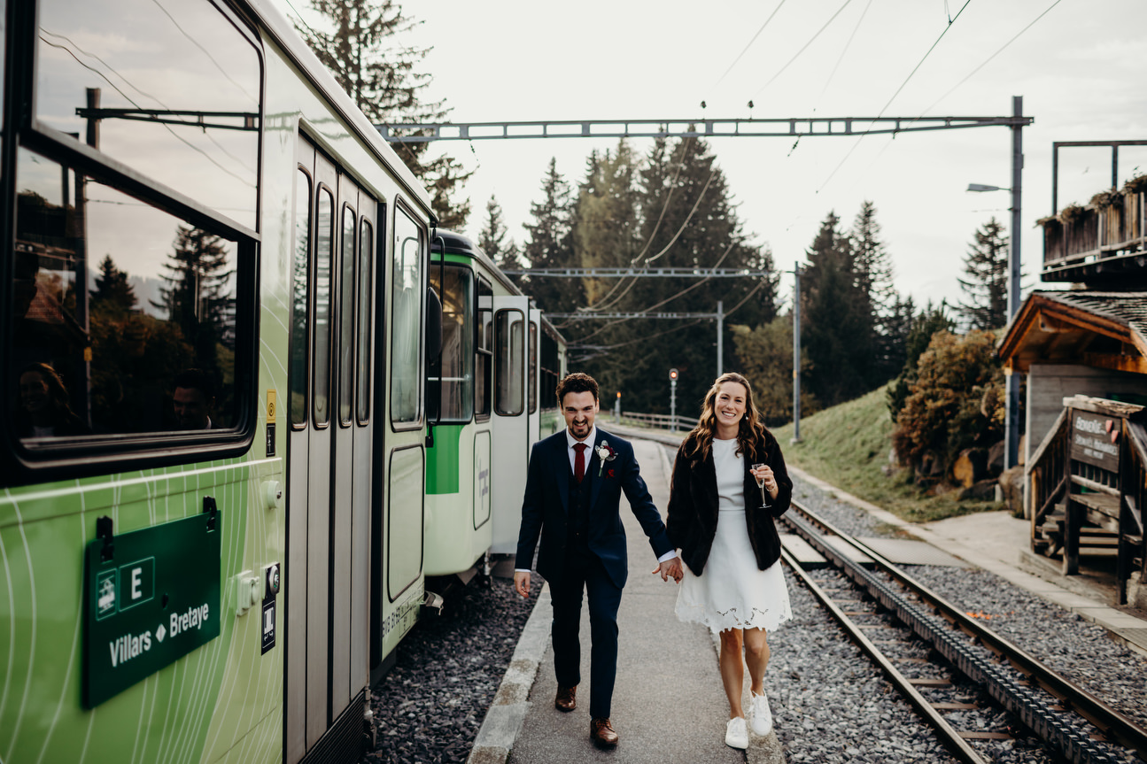 bride and groom taking a train up to Villars golf club for alps wedding
