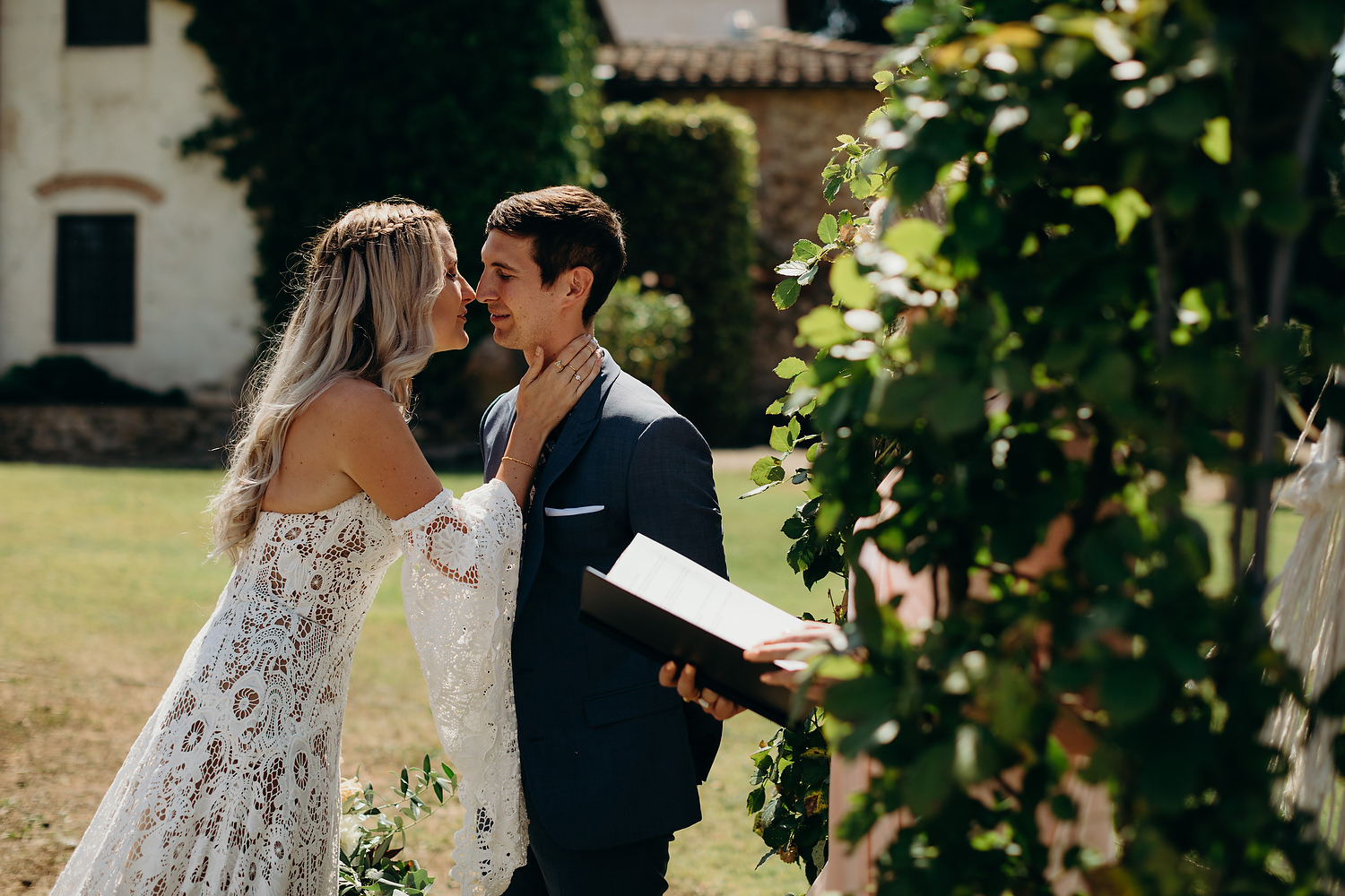 bride kissing groom as she meets at their outdoor ceremony in Tuscany