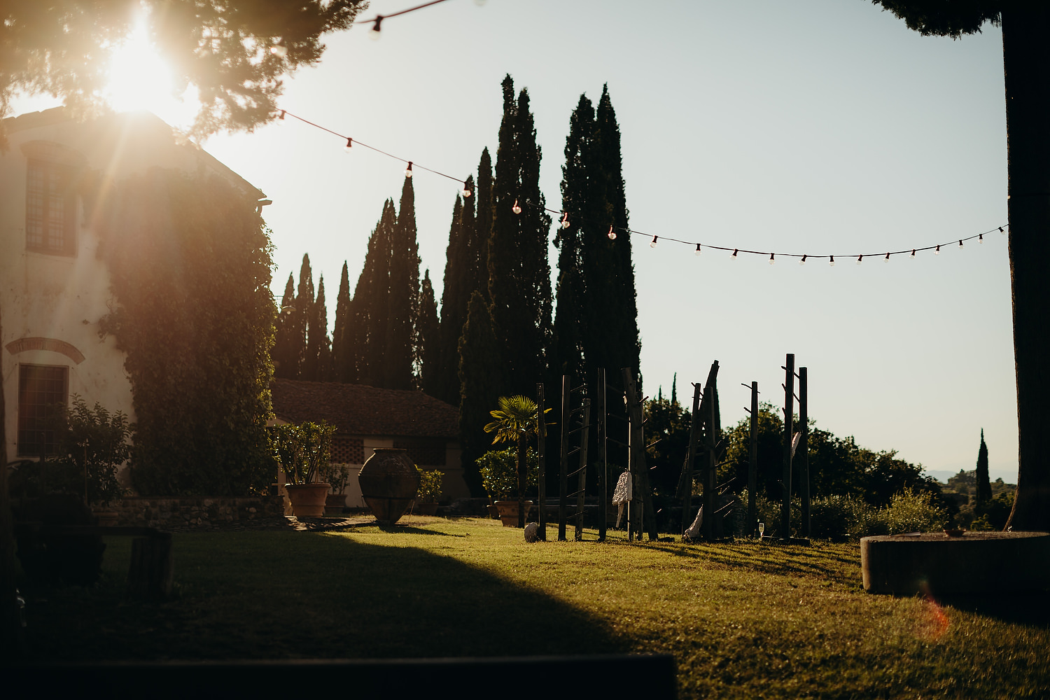 Tuscan villa in evening with sun flare and trees in the background