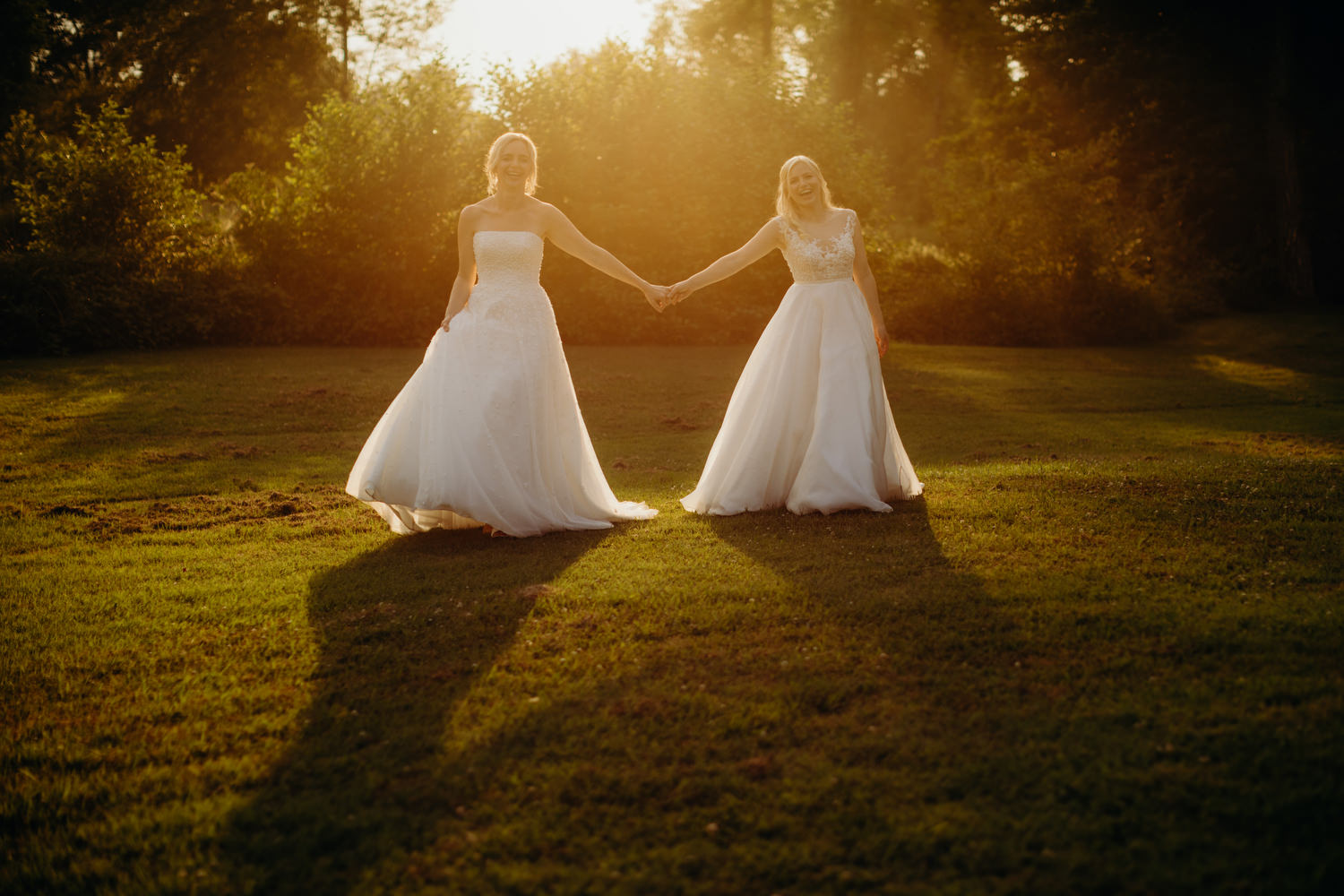 brides pose for photographs at sunset