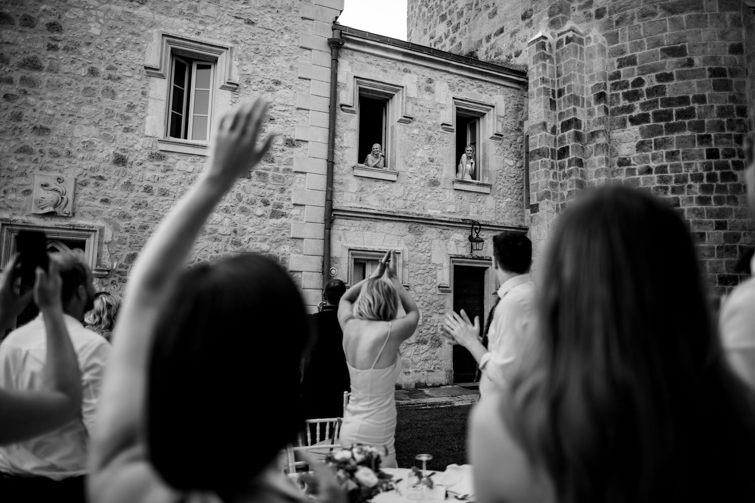brides sing song guests from chateau balcony at wedding in France