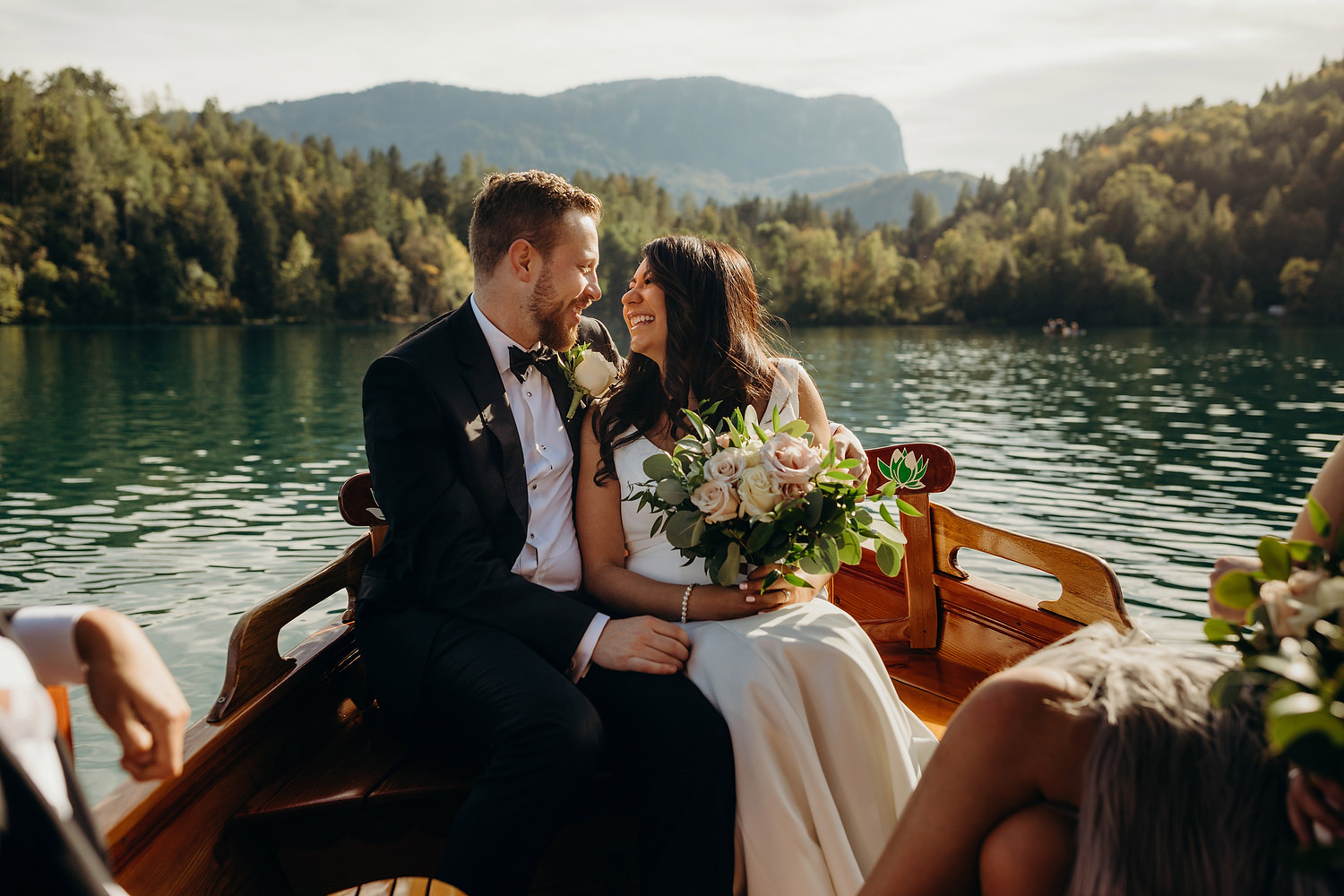 bride and groom get close with lake bled in background