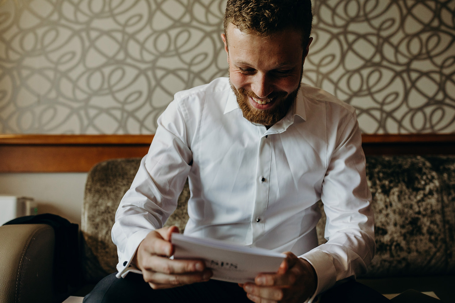 groom reading card from bride on morning of wedding