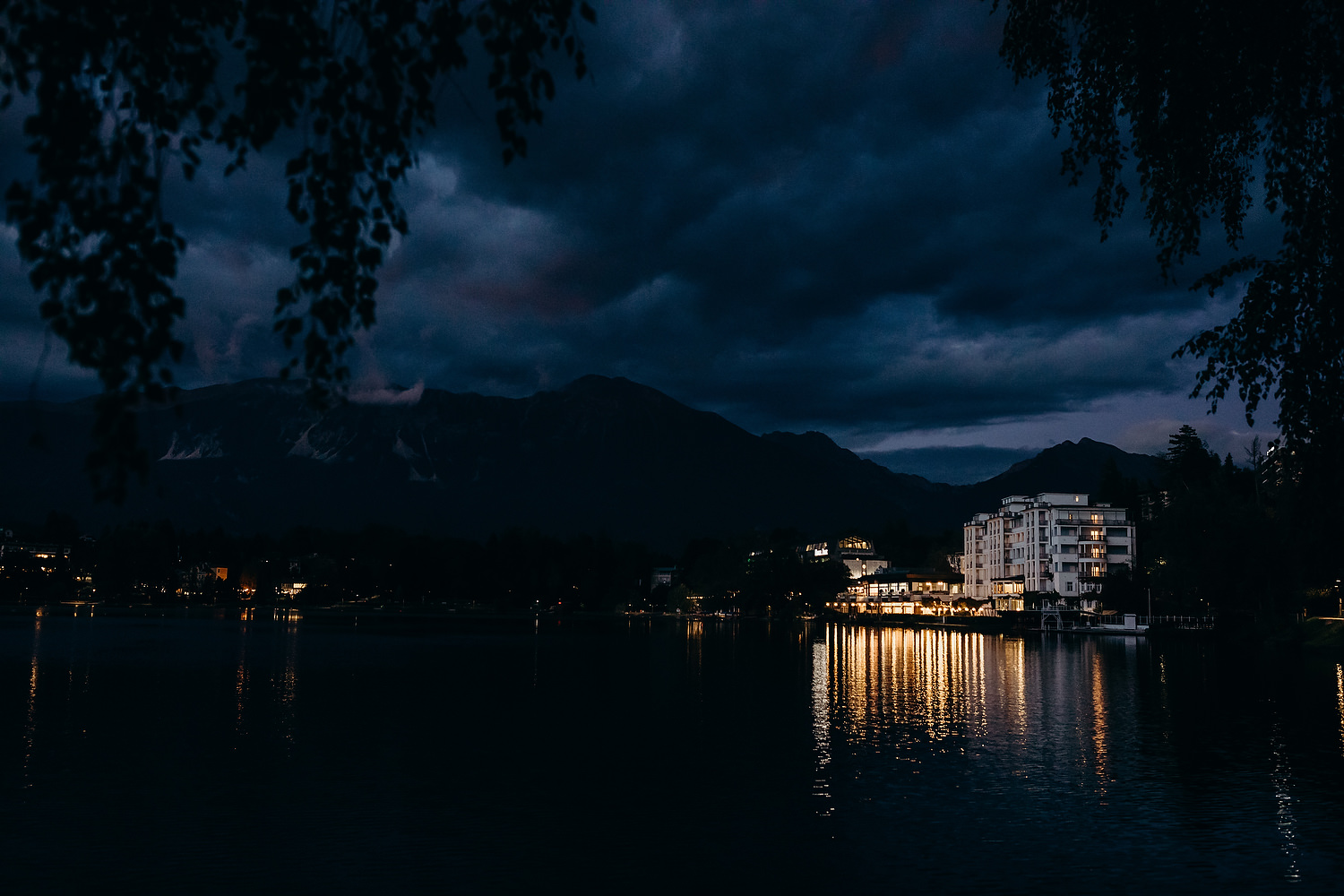 lake bled lit up at night time by hotel