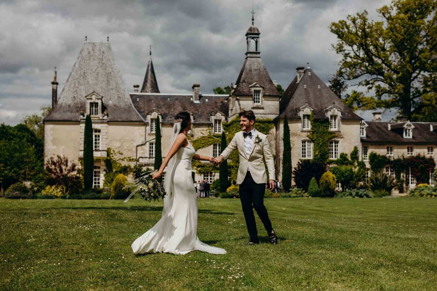 bride dances with groom with chateau in the background