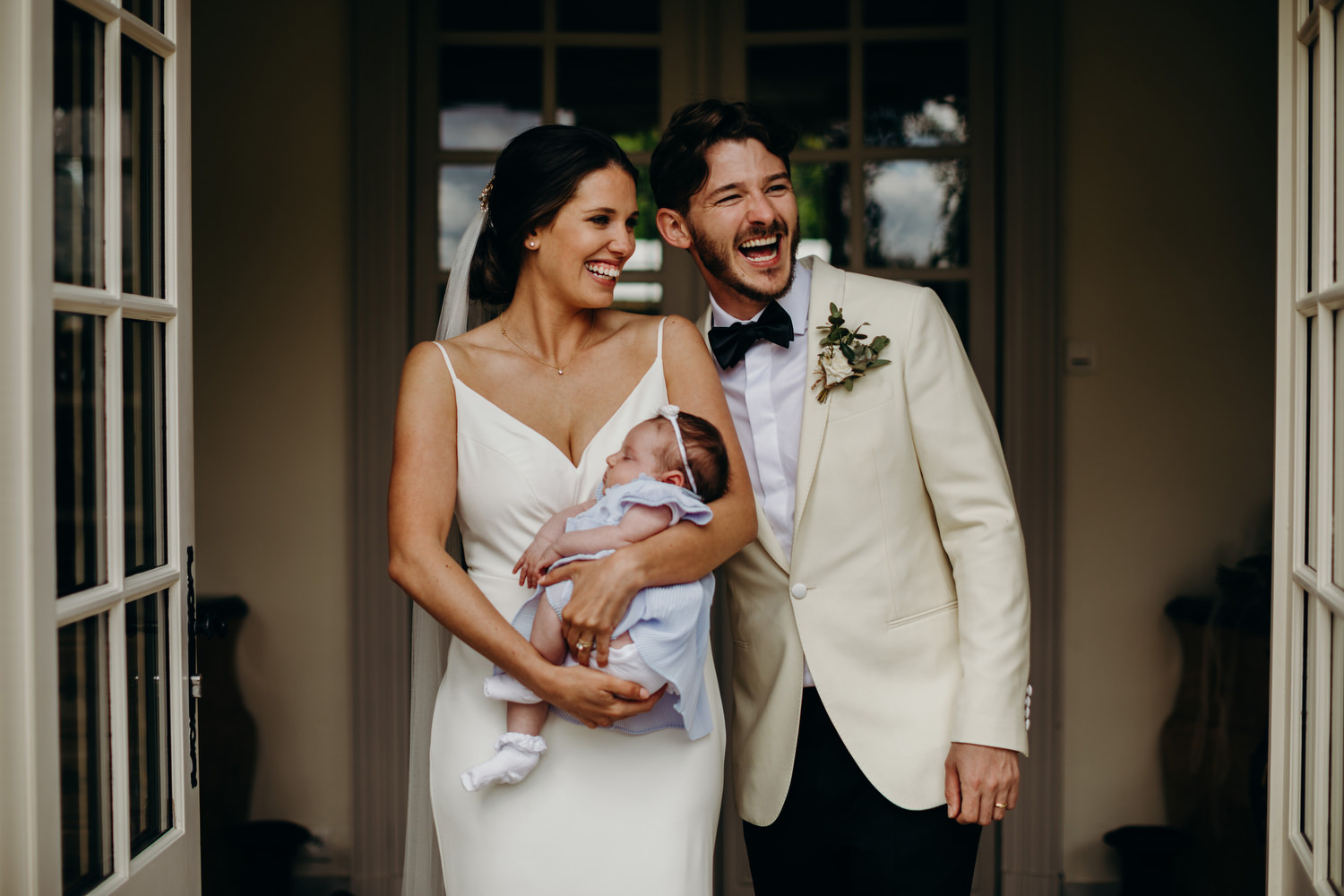 bride and groom with their baby