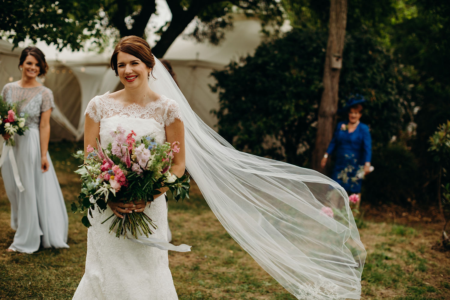 bride with bouquet veil blowing in the wind