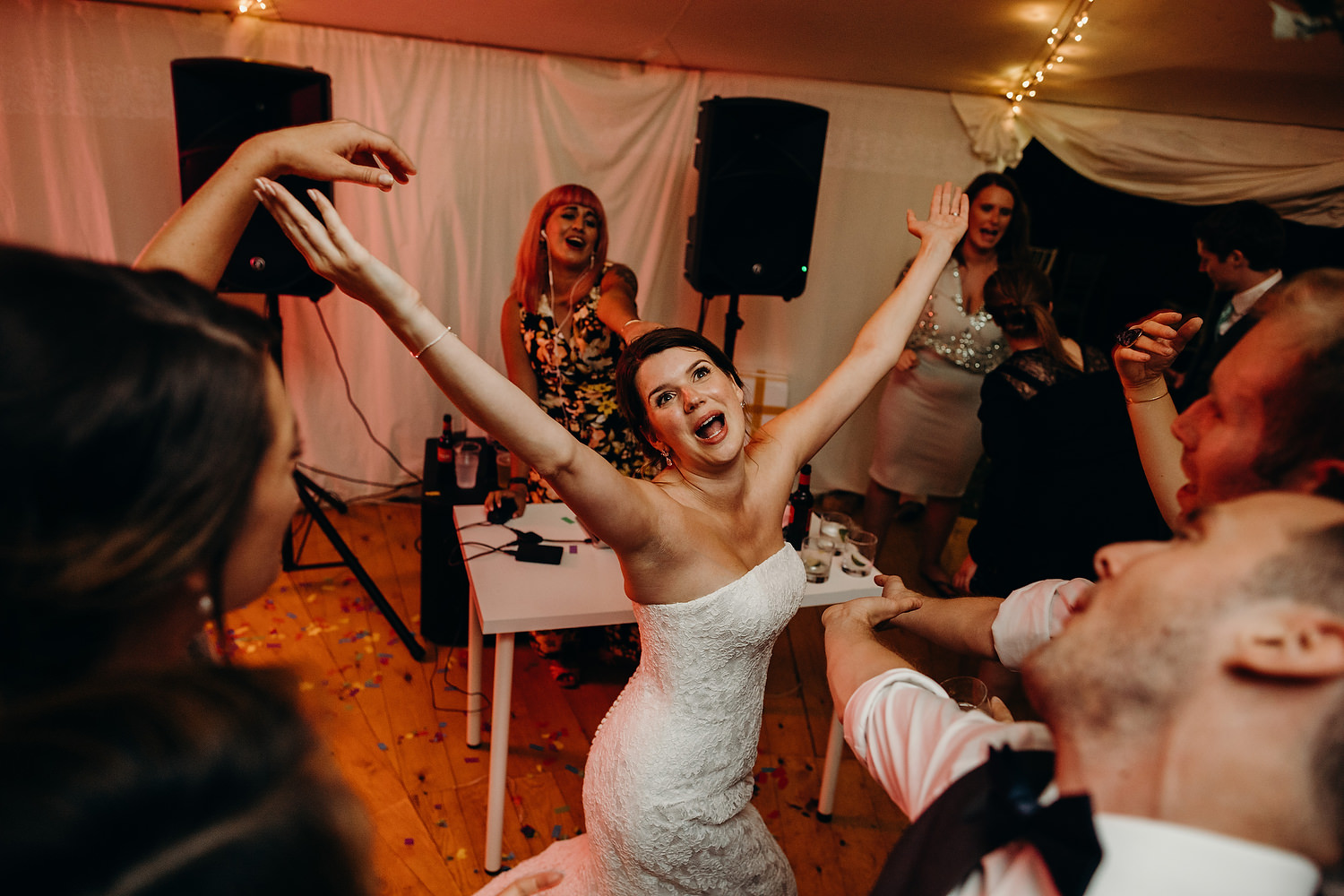bride dances with hands in air at wedding in Malvern