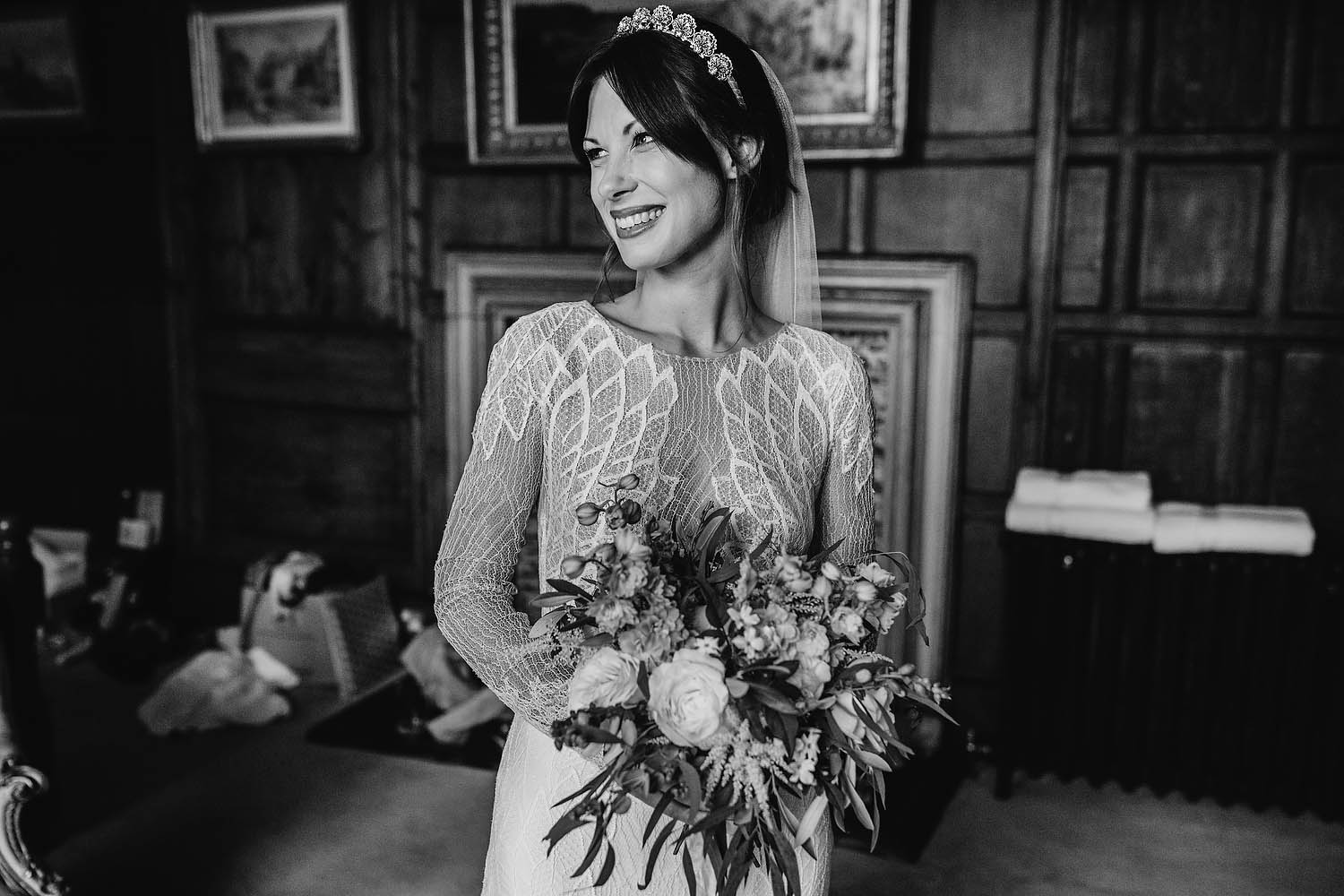 B&W image of bride smiling holding bouquet