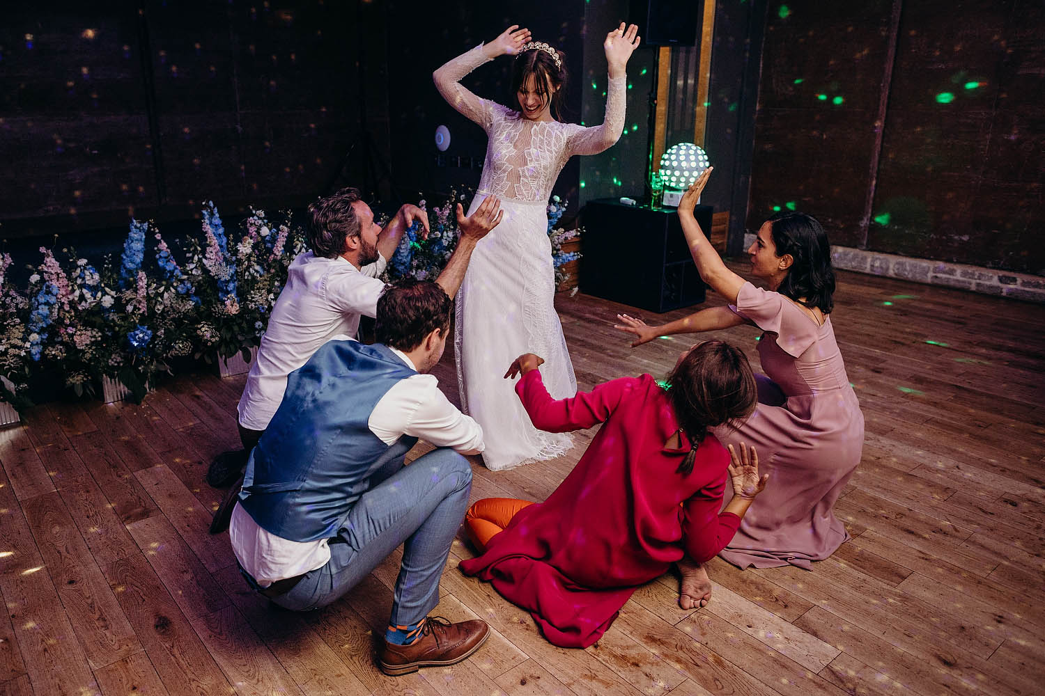 guests surround bride as she dances with hands in the air