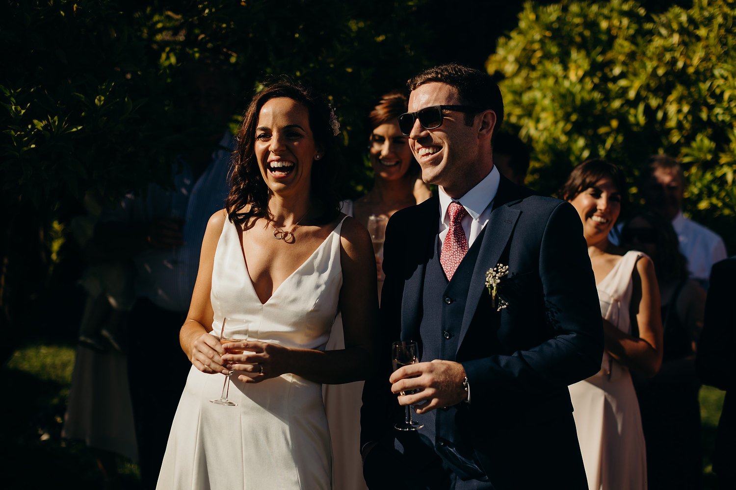 bride and groom laughing during outdoor speeches