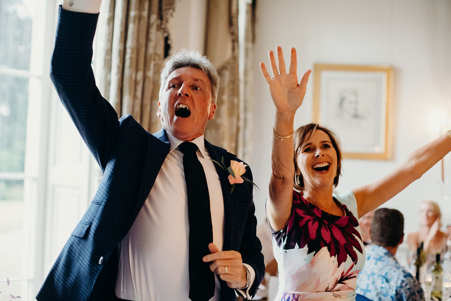 guests throw hands up in the air during wedding speeches