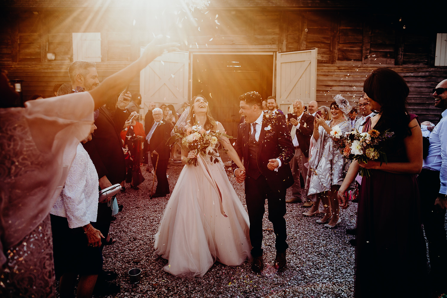bride and groom getting showered with confetti at sunset