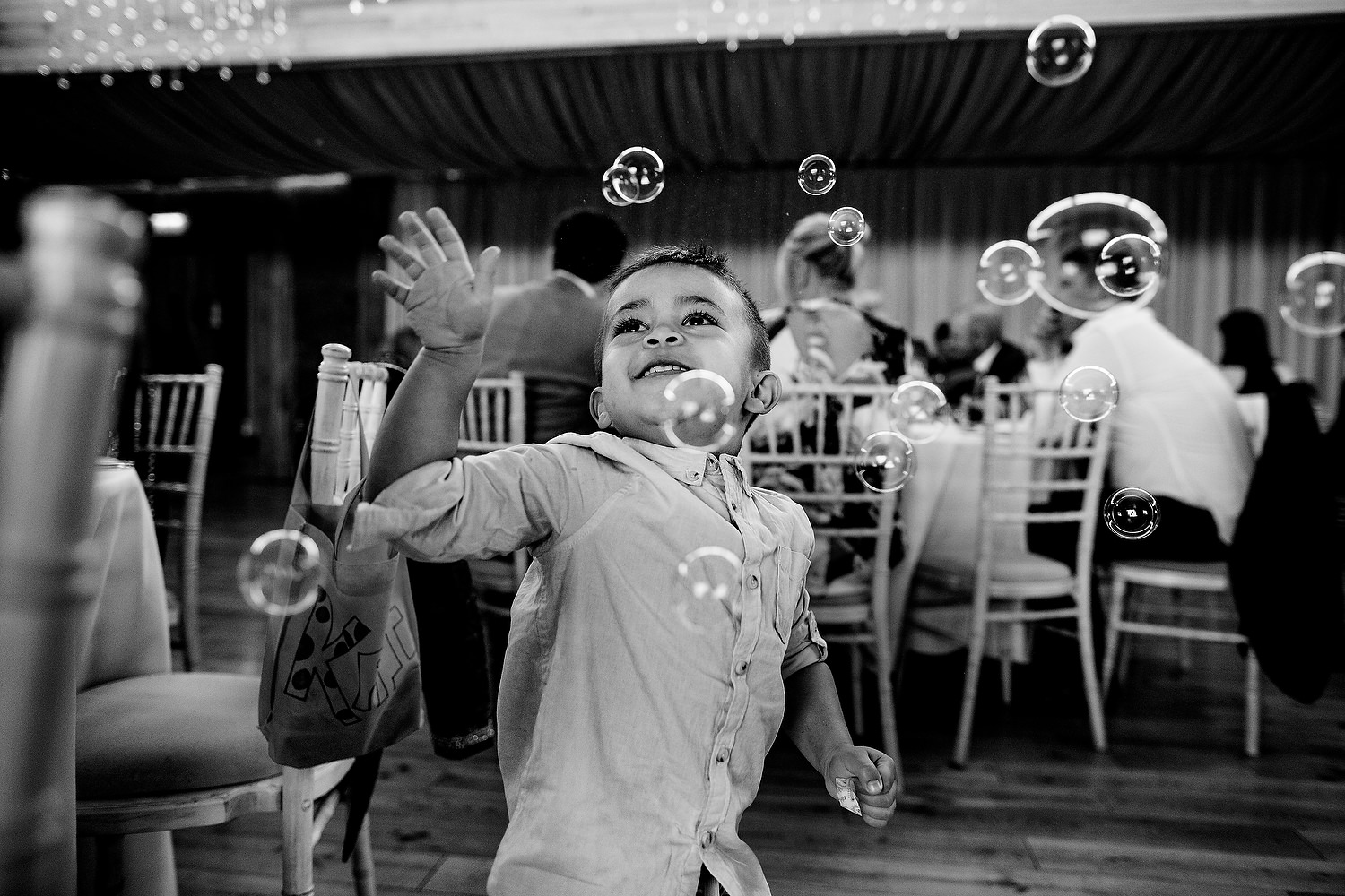 kid catching bubbles at wedding