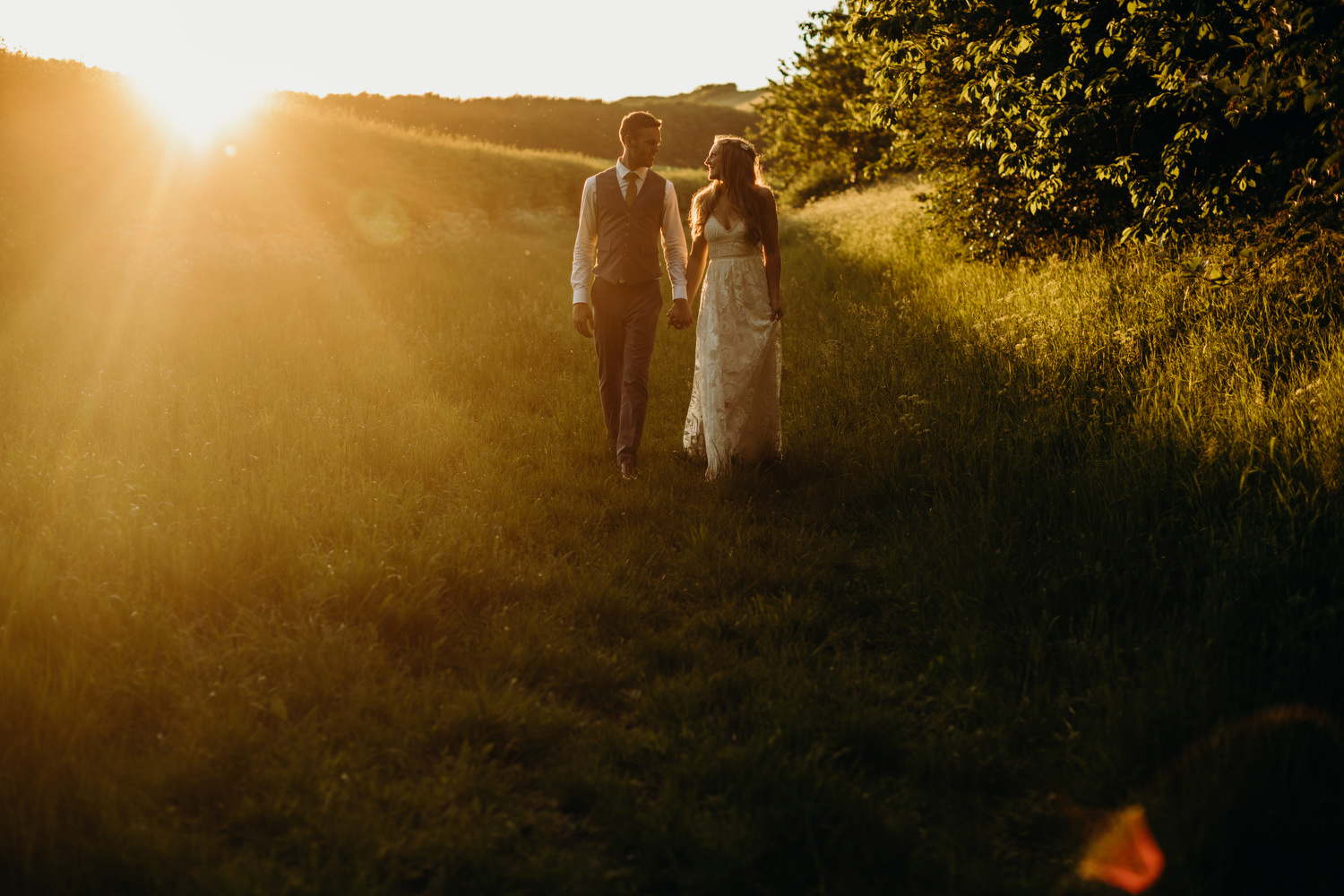 bride and groom walk at sunset at Wiltshire wedding