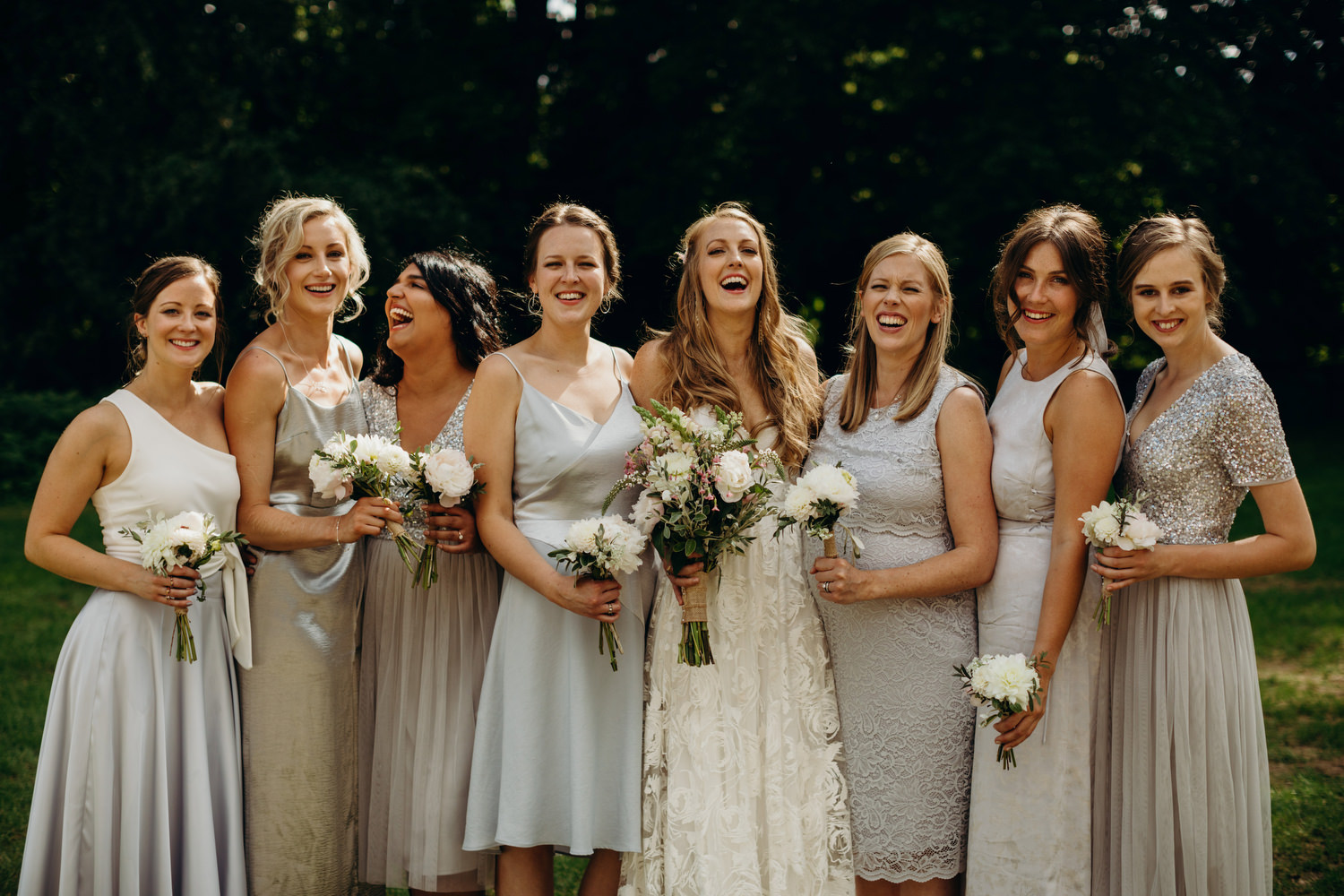 bride poses with bridesmaids at wedding