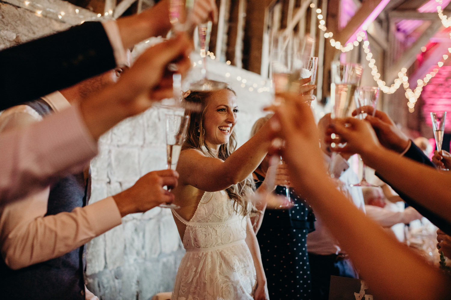 bride puts glass in air with guests at the end of speeches