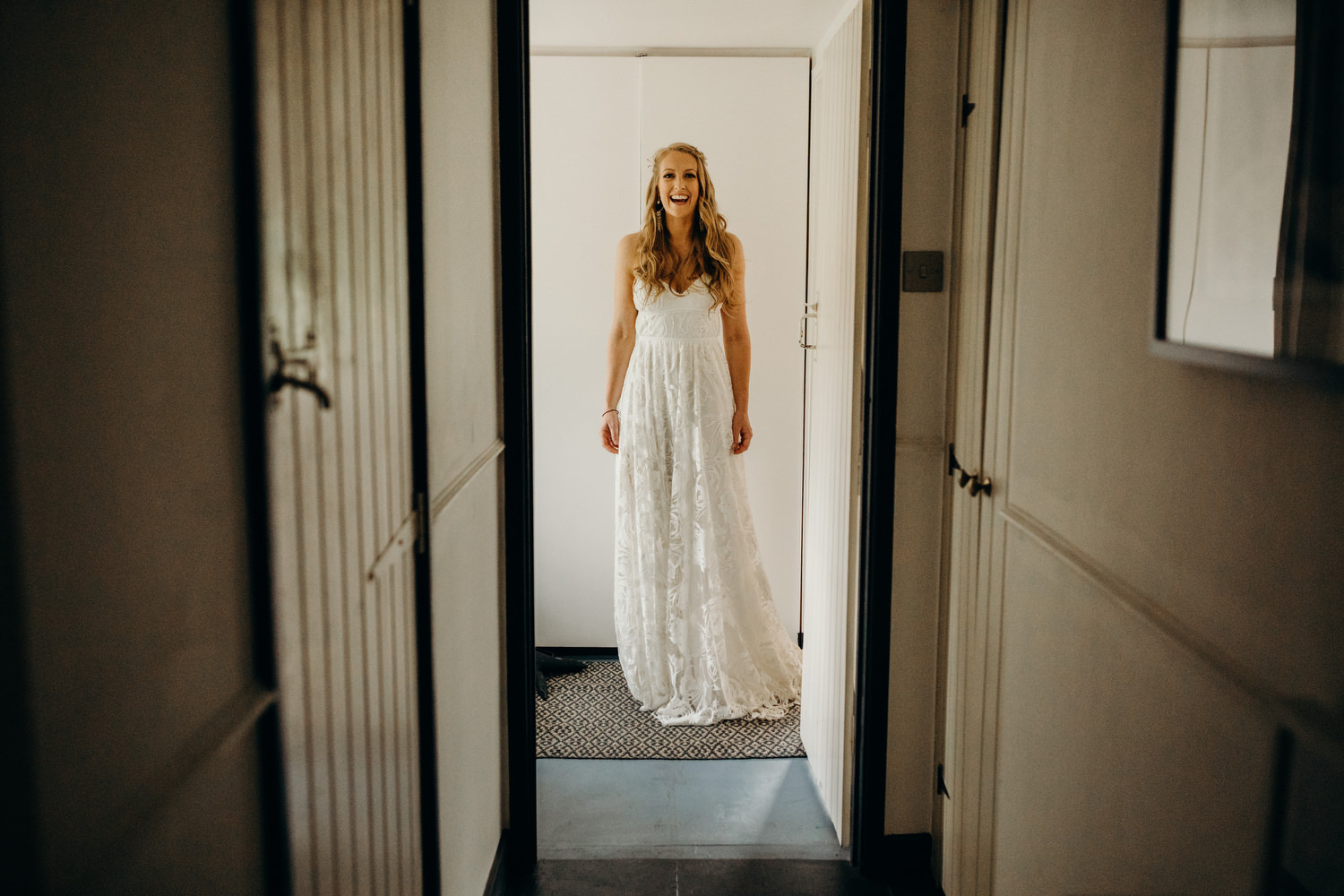 bride walking through house after just getting into wedding dress