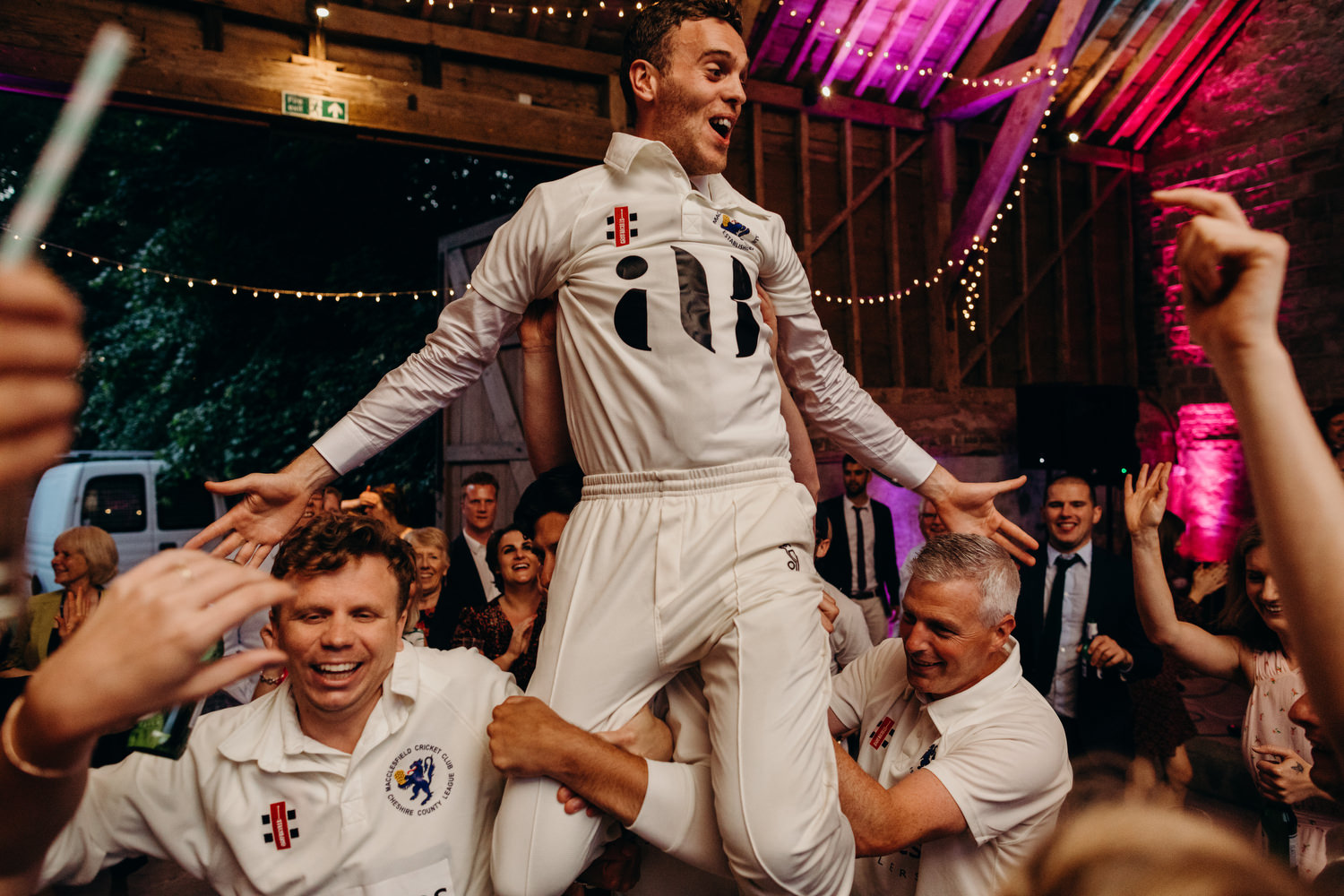 groom gets lifted up in the air by friends at wedding party