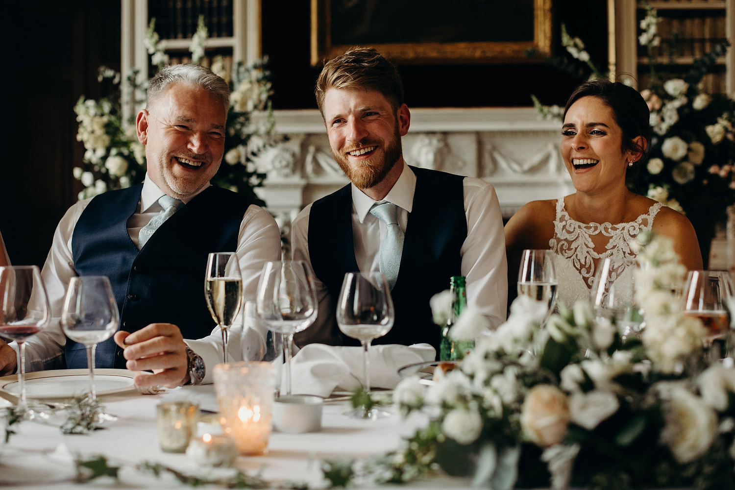 bride and groom and father laughing during wedding speeches