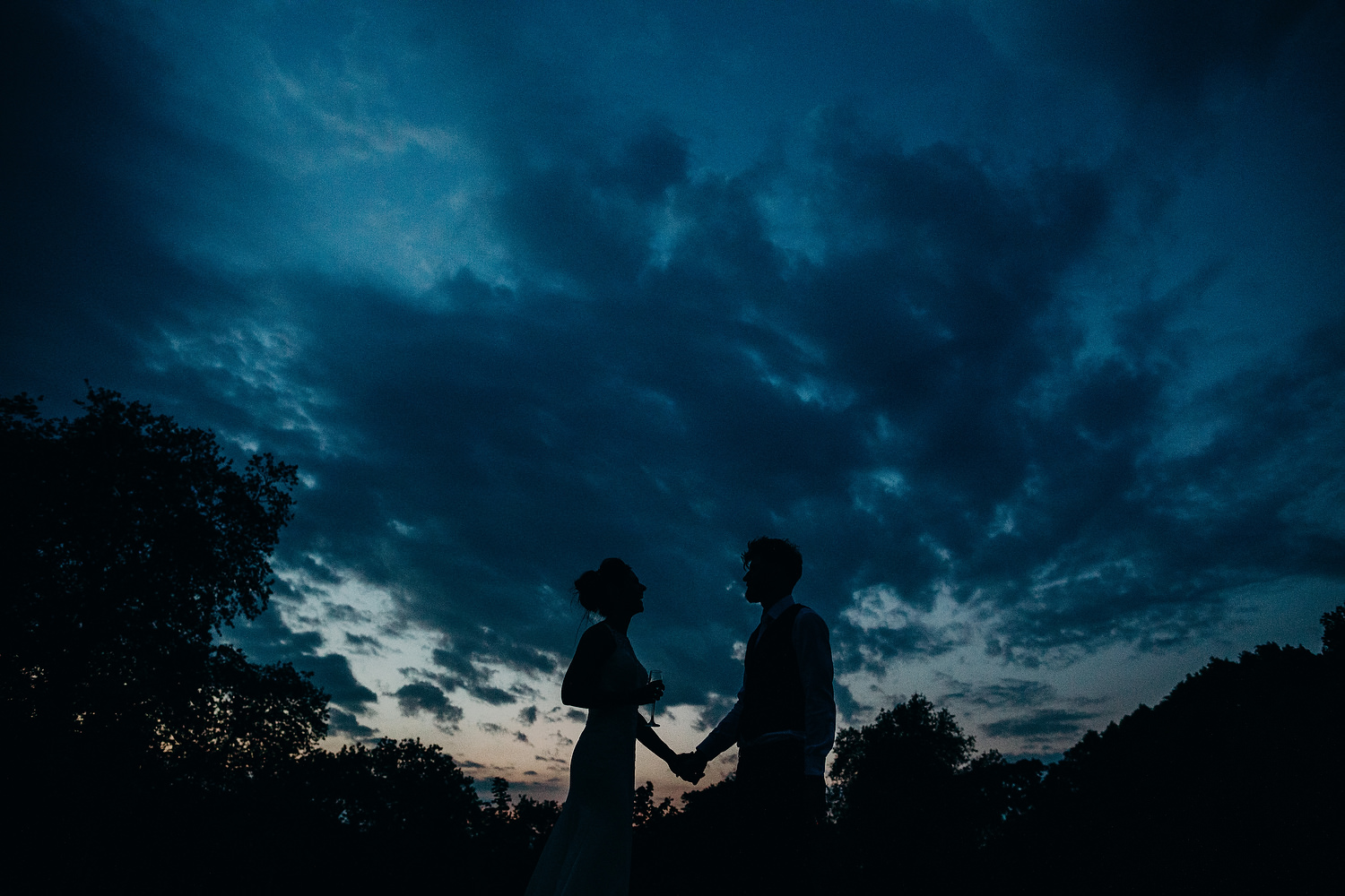 bride and groom silhouette with dark blue sky behind