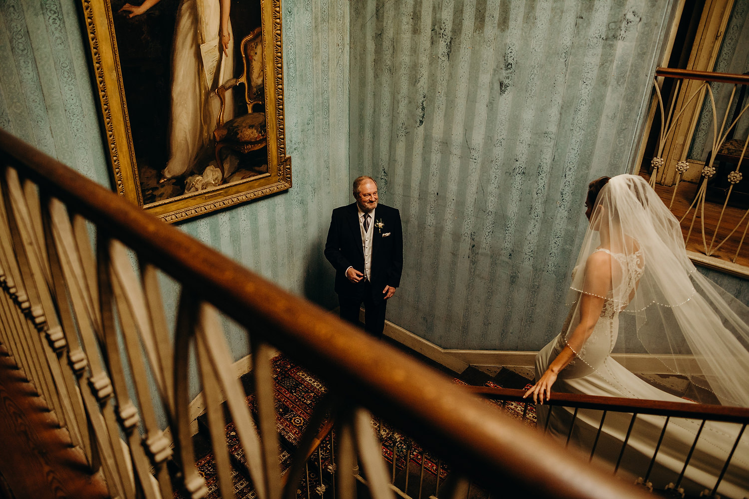father of bride waits down stairs for bride to arrive
