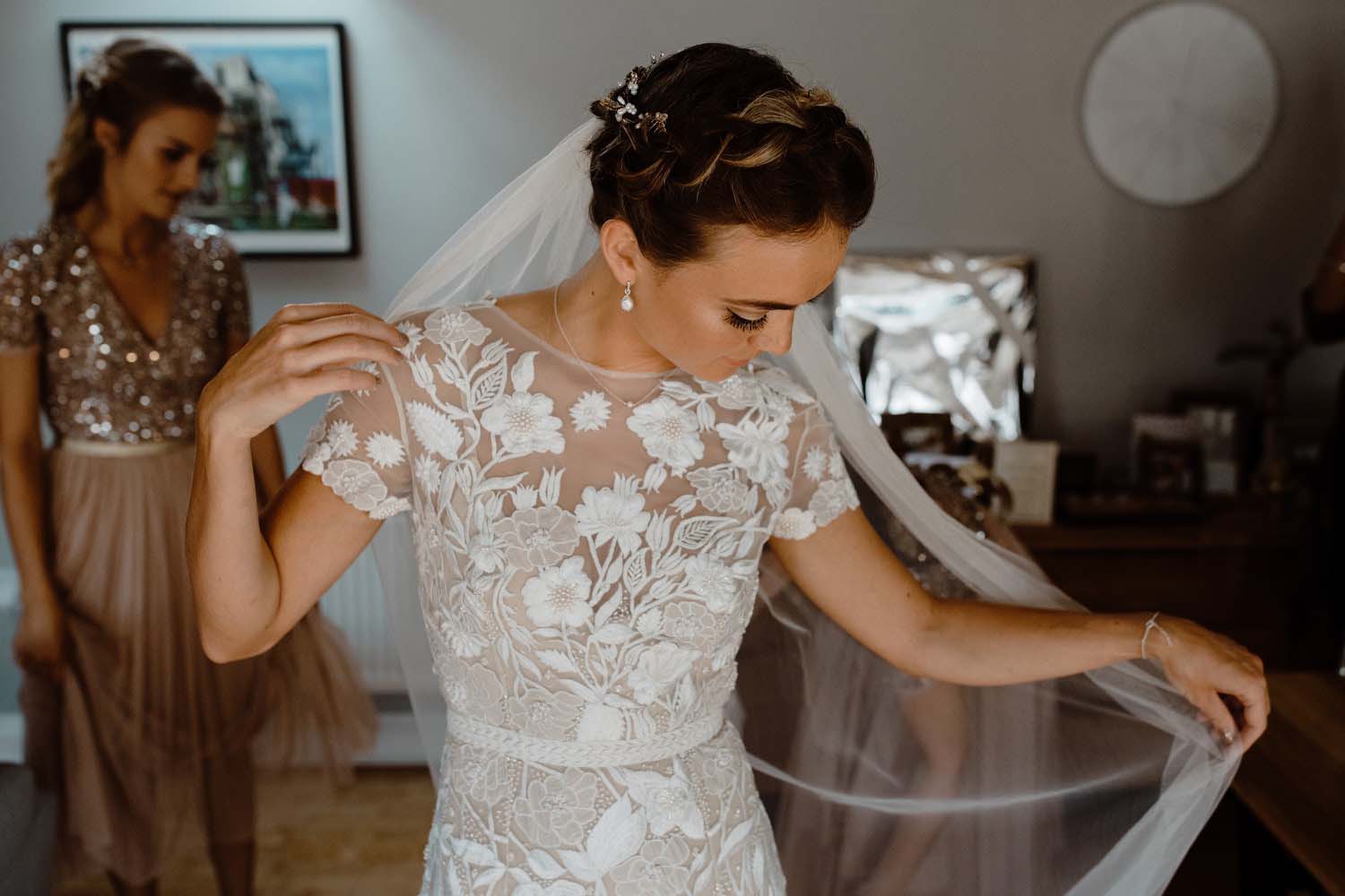 bride in lace dress adjusts veil 